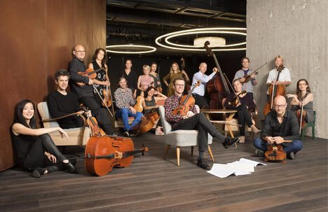 Ein Fotos zeigt die Mitglieder eines Orchesters.
