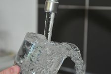 Glas wird unter einem Wasserhahn gefüllt